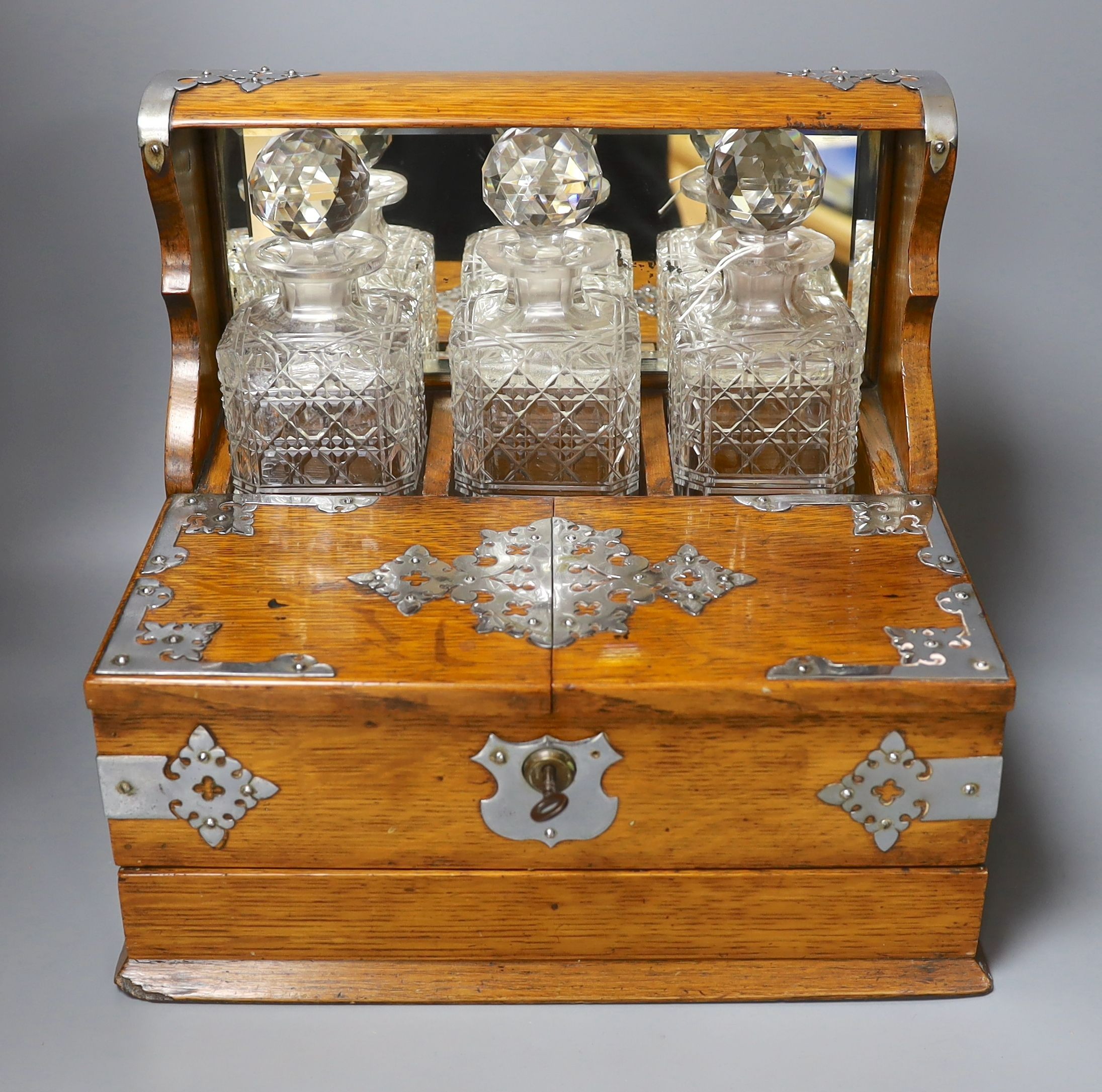 An Edwardian oak tantalus and combination games box with key - 33cm tall